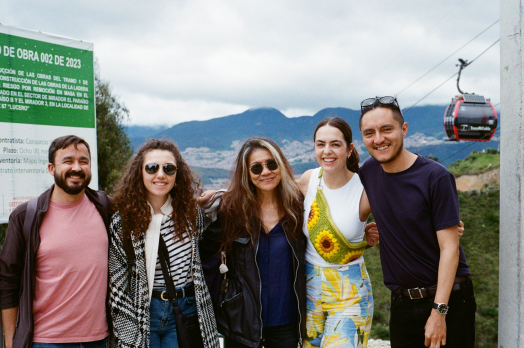 A small group of Summer Institute participants pose for a picture in front of a cable-car in Bogota.